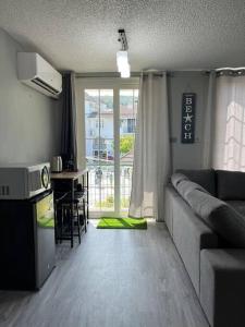 欧丘里欧Panorama Ochi - Sand Castles Resort B20的带沙发的客厅和带窗户的厨房