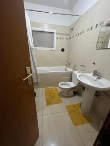 达喀尔Villa spacieuse et agréable的浴室配有盥洗盆、卫生间和浴缸。