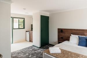 黄金海岸Wallaby Hotel的一间卧室设有一张大床和一扇绿门