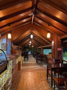KamadhooSand Inn Residence的餐厅设有木制天花板和木桌及椅子