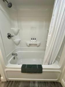 谢蒂坎普Cheticamp Outback Inn的浴室内设有带绿毛巾的白色浴缸