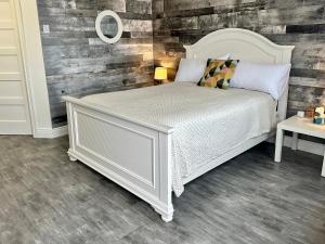 谢蒂坎普Cheticamp Outback Inn的卧室配有白色的床和木墙