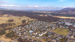 阿维莫尔Eagle Lodge - Aviemore Lodges的山丘上小村庄的空中景观