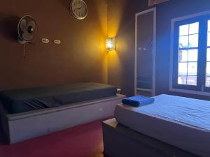 南圣胡安Buena Onda Backpackers的一间卧室设有两张床,墙上挂着一个时钟。