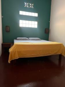 南圣胡安Buena Onda Backpackers的一间卧室配有一张黄色毯子床