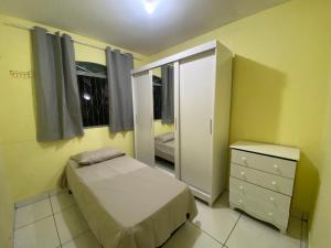 大坎普Casa Camargo - mobiliada, cozinha completa的一间卧室配有一张床、一个梳妆台和一扇窗户。