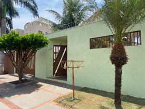 大坎普Casa Camargo - mobiliada, cozinha completa的一座绿屋,前面有棕榈树