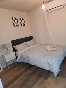 罗姆福特1-bed flat near Romford station的一间卧室配有一张床和一张带台灯的桌子