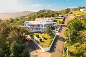 Humacao Villa - 8BR, Pool, Palmas, Ocean Views的山丘上大房子的顶部景色