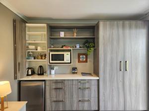 哈海Hahei Getaway Rua的厨房配有冰箱和微波炉。
