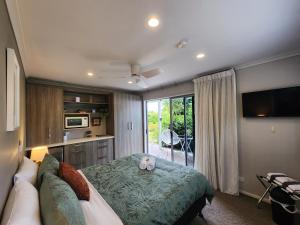 哈海Hahei Getaway Rua的一间卧室配有一张床、一张沙发和一台电视。