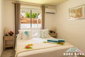 波拉波拉Matira Beach House的带窗户的客房内的两张床