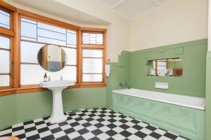 吉斯伯恩Art Deco Charm - Amazing River Views Inner City的绿色浴室设有浴缸和水槽