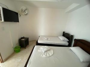 图卢阿Hotel Lina Maria的小房间设有两张床和风扇