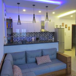 海尔盖莱Appartement moderne, vue mer的一间带蓝色沙发的客厅和一间厨房