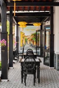 会安Thien Thanh Central Boutique Hotel的一个带桌椅和遮阳伞的庭院