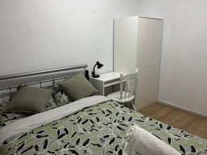 珀斯double room share bathroom and kitchen的一间卧室配有一张床和一个带灯的床头柜