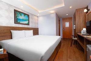 芽庄BIDV Beach Hotel Nha Trang的卧室配有一张白色大床和一张书桌