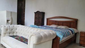 San Lucas SacatepéquezCabaña privada的卧室配有一张白色沙发,毗邻一张床