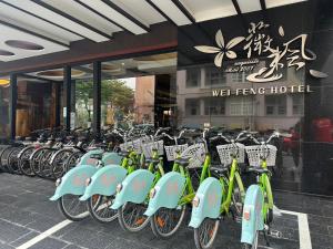 屏东县薇风精品商务旅馆（站前馆） 的停在大楼前的一排绿色自行车
