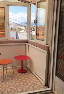 波德戈里察*Ana Maria*Hostel/rooms&bunk bed的阳台配有红色桌子和2张凳子
