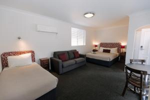 沃加沃加中点汽车旅馆的酒店客房,设有两张床和一张沙发