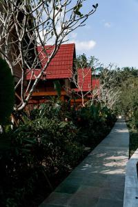 塞莱马德加Kusfarm Bali的一座有红色屋顶和走道的房子