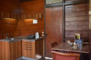 普卡Citra Cikopo Hotel & Family Cottages的厨房设有木墙、桌子和水槽