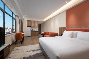 佳木斯佳木斯万达锦寓公寓酒店的酒店客房带一张床和一个厨房