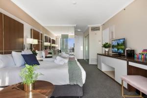 黄金海岸Comfy Surfers Paradise Studio with Ocean View的酒店客房设有两张床和电视。