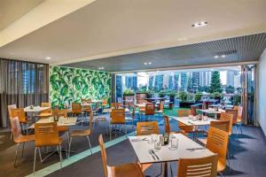 黄金海岸Comfy Surfers Paradise Studio with Ocean View的餐厅设有桌椅和大窗户。