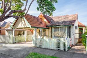 悉尼Spacious 3-Bed Mid Century Home Near CBD的白色围栏的黄色房子