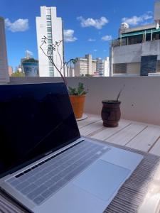 拉普拉塔La Plata Housing I的坐在阳台上的一张桌子上的笔记本电脑