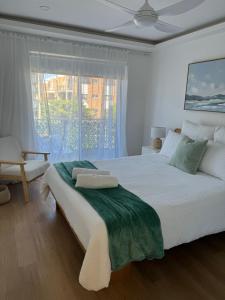 黄金海岸鹈鹕湾公寓酒店的白色的卧室设有一张大床和一个窗户