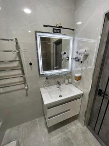 纳沃伊Art Hotel Navoiy的一间带水槽、镜子和淋浴的浴室