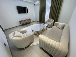 纳沃伊Art Hotel Navoiy的客厅配有沙发和桌椅
