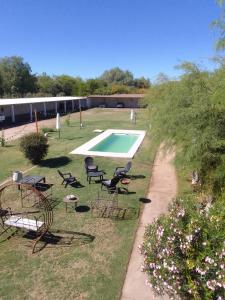 多洛雷斯镇Hotel Hualum的一个带椅子的庭院和一个游泳池