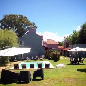多洛雷斯镇Hotel Hualum的庭院内一个带椅子和遮阳伞的游泳池