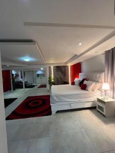 圣多明各Penthouse Bella的卧室配有白色的床和红色窗帘