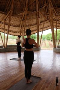 WaikeloMaringi Sumba by Sumba Hospitality Foundation的两个站在瑜伽室的女人摆着一个姿势