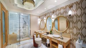 后川InterContinental Grand Ho Tram的一间带两个盥洗盆、镜子和淋浴的浴室