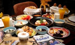 曼谷曼谷瓦利亞酒店 (Valia Hotel Bangkok)的桌子上摆放着食物和饮料的桌子