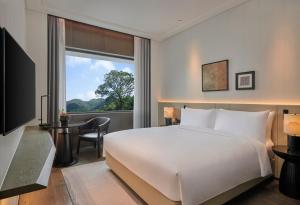 广州广州鸣泉居酒店的一间卧室配有一张床、一张书桌和一个窗户。