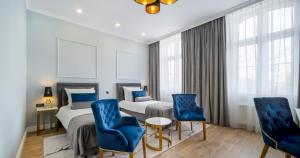 乔左维尔考普尔斯基Hotel Pavco的酒店客房,配有两张床和蓝色椅子