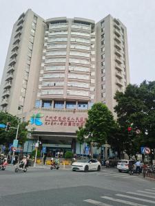 花都柏高酒店(广州北站花城路地铁站店)的一座大型建筑,前面有停车位