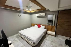 艾哈迈达巴德Hotel Om Balaji的卧室配有白色的床和红色枕头