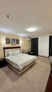 塔什干Hayot Hotel的一间大卧室,内配一张白色的大床