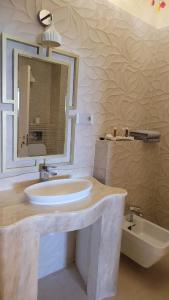 雅西Terrace Suites Iasi的浴室配有盥洗盆、镜子和浴缸