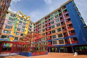 曼那Style Sukumwit Bangna 1的大型公寓大楼设有色彩缤纷的窗户