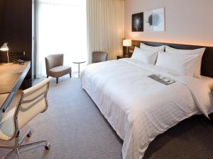 台北台北寒舍艾美酒店 的酒店客房设有一张大床和一张书桌。